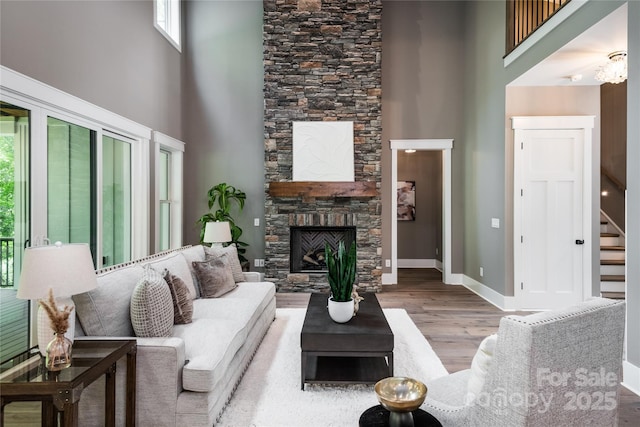 7703 Juniper Ln, Denver, NC 28037 - living area with a towering ceiling, stairs, wood finished floors, a fireplace, and baseboards