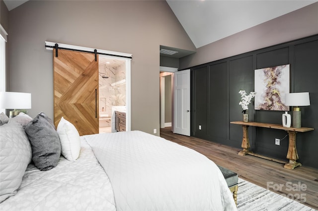 7703 Juniper Ln, Denver, NC 28037 - bedroom featuring wood finished floors, high vaulted ceiling, a barn door, and connected bathroom