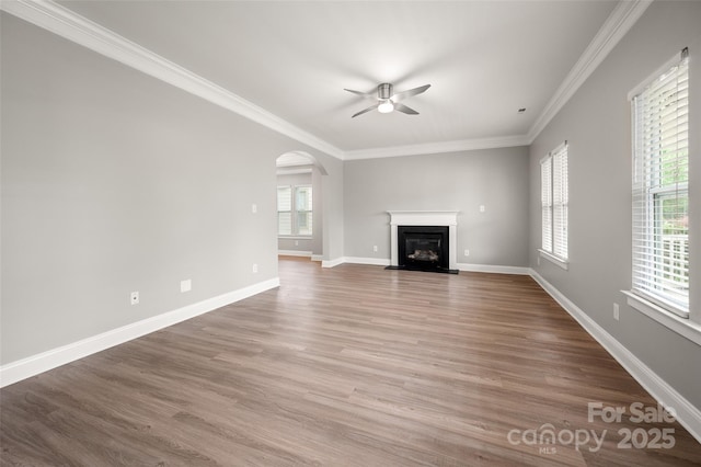 14034 Cedar Pond Cir, Huntersville, NC 28078 - unfurnished living room with a ceiling fan, arched walkways, crown molding, wood finished floors, and a fireplace with flush hearth