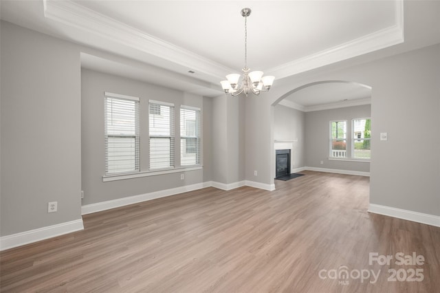 14034 Cedar Pond Cir, Huntersville, NC 28078 - unfurnished living room with a raised ceiling, crown molding, arched walkways, light wood-type flooring, and a fireplace with flush hearth