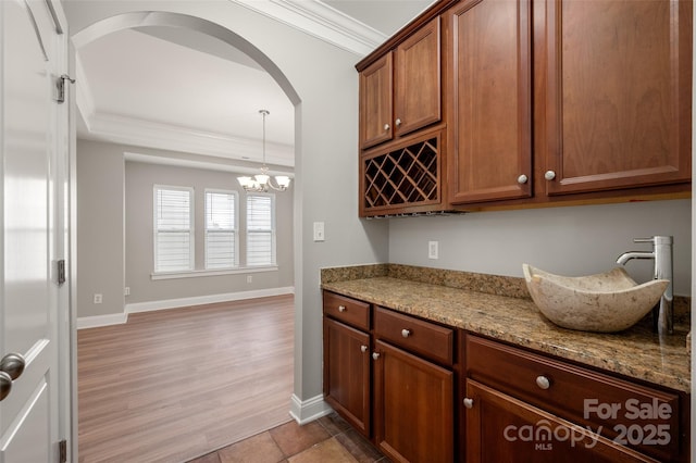 14034 Cedar Pond Cir, Huntersville, NC 28078 - kitchen with ornamental molding, a sink, arched walkways, baseboards, and a chandelier