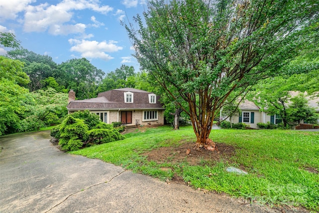 9139 Robert Frost Ln, Charlotte, NC 28213 - colonial inspired home with brick siding, a chimney, a front yard, roof with shingles, and driveway
