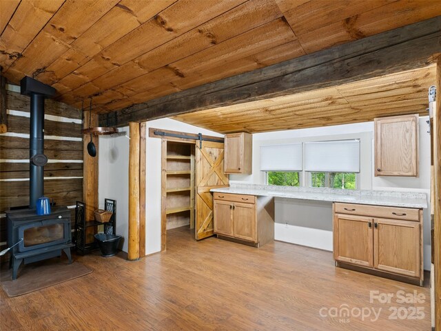 161 Moody Mountain Rd, Burnsville, NC 28714 - kitchen with light wood finished floors, wood ceiling, light countertops, a wood stove, and a barn door
