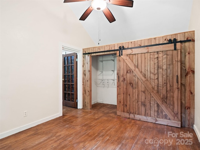 161 Moody Mountain Rd, Burnsville, NC 28714 - unfurnished room with ceiling fan, wood-type flooring, a barn door, vaulted ceiling, and baseboards