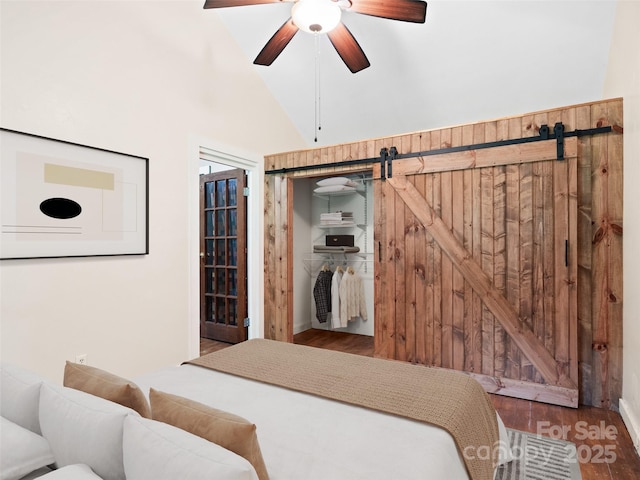 161 Moody Mountain Rd, Burnsville, NC 28714 - bedroom with a barn door, wood finished floors, a ceiling fan, a closet, and high vaulted ceiling