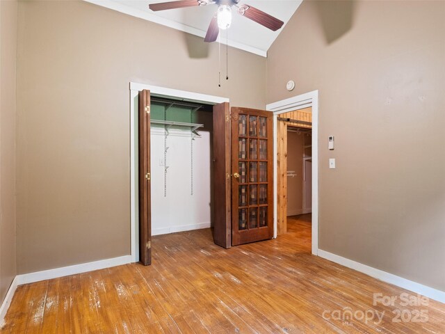 161 Moody Mountain Rd, Burnsville, NC 28714 - unfurnished bedroom with wood-type flooring, high vaulted ceiling, baseboards, a ceiling fan, and a closet