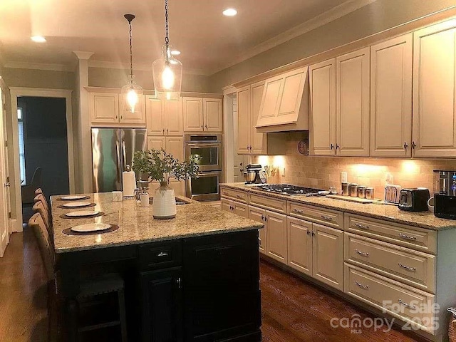 kitchen with appliances with stainless steel finishes, custom range hood, crown molding, decorative backsplash, and decorative light fixtures