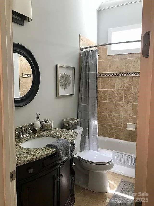 bathroom with toilet, vanity, shower / bath combo, and tile patterned floors
