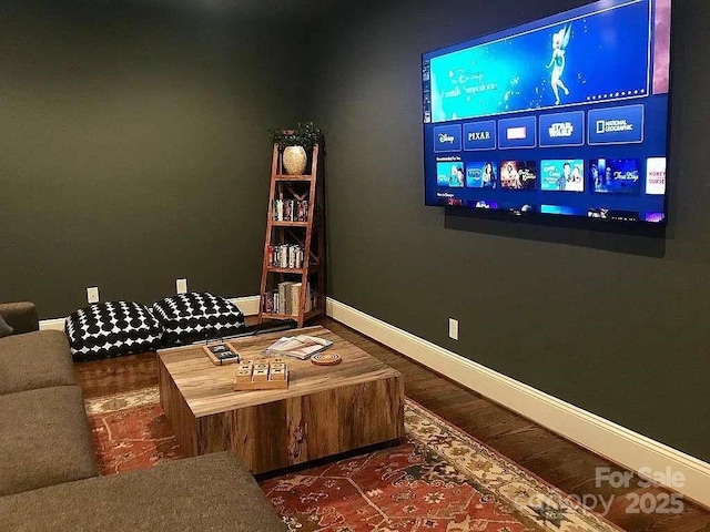 home theater room featuring baseboards and wood finished floors
