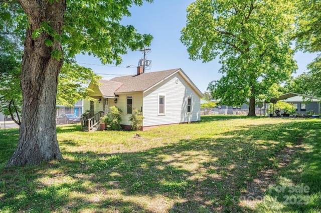 3042 N Oxford St, Claremont, NC 28610 - view of side of home featuring a chimney, roof with shingles, and a carport