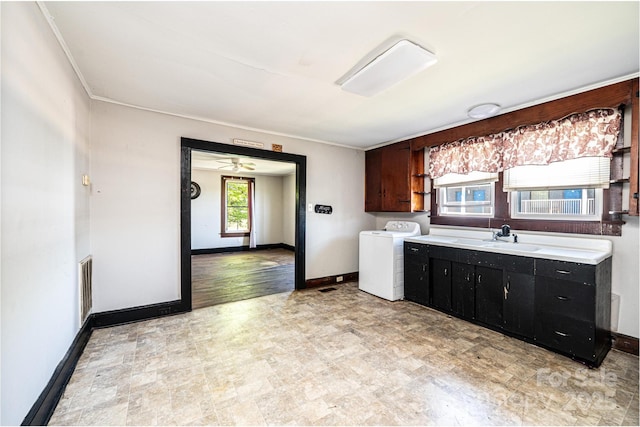 3042 N Oxford St, Claremont, NC 28610 - kitchen featuring washer / clothes dryer, light countertops, baseboards, a sink, and crown molding
