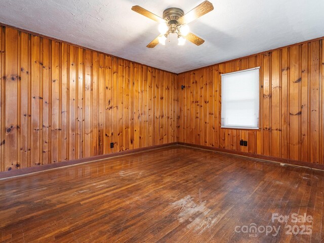 876 Stowe Ln, Gastonia, NC 28056 - spare room featuring hardwood / wood-style floors, ceiling fan, and wood walls