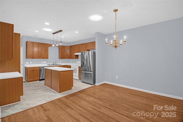 4467 Antelope Ln, Charlotte, NC 28269 - kitchen featuring appliances with stainless steel finishes, a chandelier, light countertops, a center island, and pendant lighting