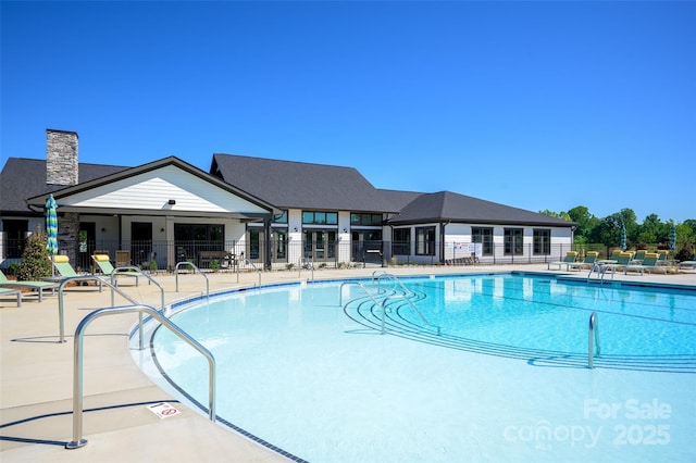 community pool with fence and a patio area