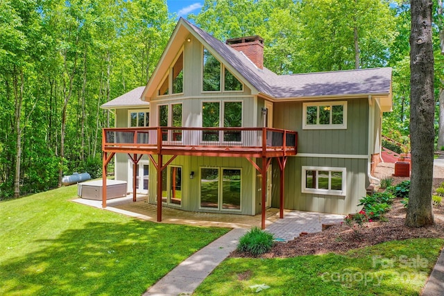 82 Sunburst Dr, Waynesville, NC 28786 - rear view of house with a hot tub, a patio area, a yard, and a chimney