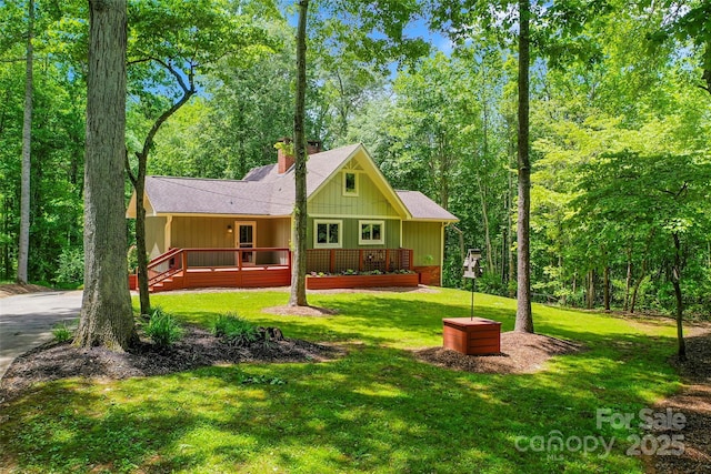 82 Sunburst Dr, Waynesville, NC 28786 - view of front of home featuring a chimney, a front yard, board and batten siding, and a wooden deck