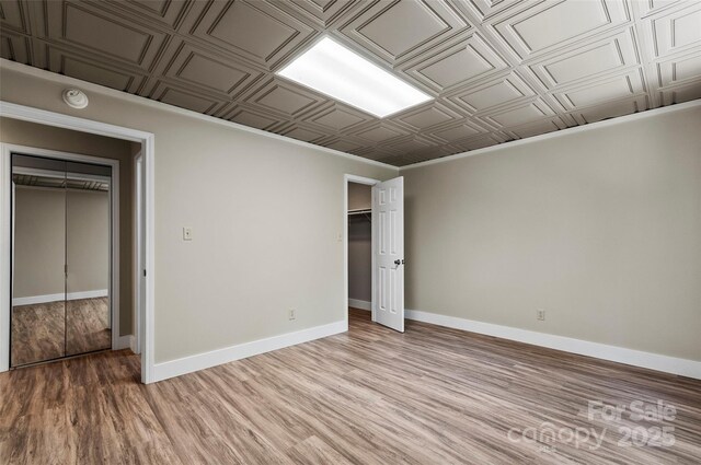 82 Sunburst Dr, Waynesville, NC 28786 - unfurnished bedroom with an ornate ceiling, light wood-style flooring, baseboards, and a closet