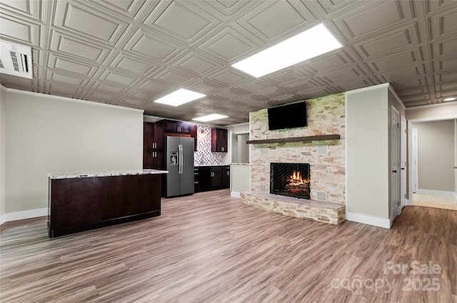 82 Sunburst Dr, Waynesville, NC 28786 - unfurnished living room featuring a stone fireplace, light wood-style floors, baseboards, and an ornate ceiling