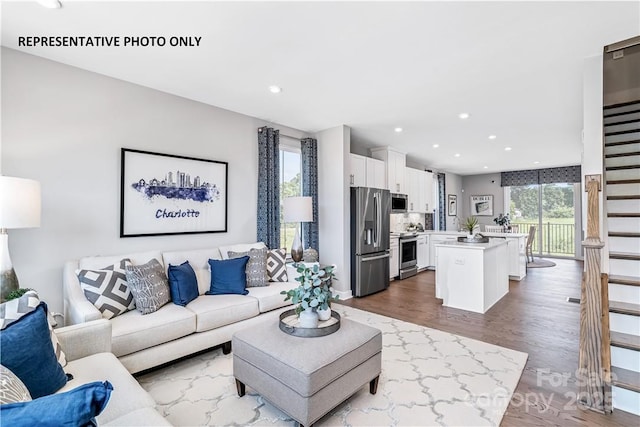 living room with wood finished floors, recessed lighting, and baseboards