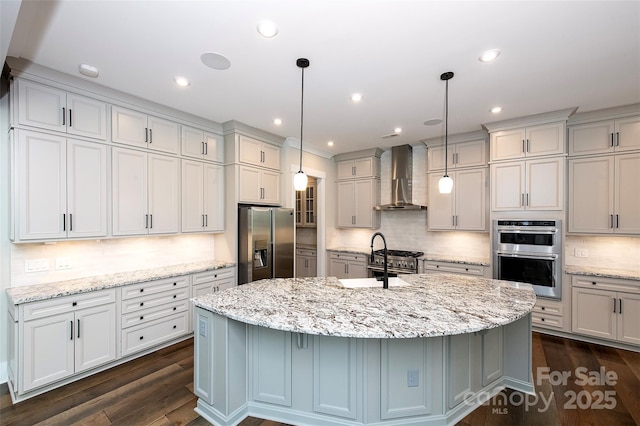 720 Cavesson Way, Monroe, NC 28110 - kitchen featuring appliances with stainless steel finishes, wall chimney exhaust hood, decorative backsplash, a kitchen island with sink, and dark wood-style floors