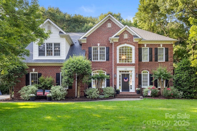 4389 Enchantment Cove Ln, Charlotte, NC 28216 - colonial home featuring a front yard, brick siding, and roof with shingles
