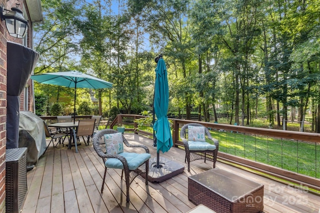 4389 Enchantment Cove Ln, Charlotte, NC 28216 - wooden deck featuring outdoor dining space, view of wooded area, a yard, and a grill