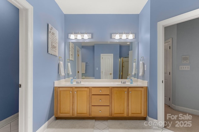 4389 Enchantment Cove Ln, Charlotte, NC 28216 - bathroom featuring baseboards, a shower stall, tile patterned floors, and double vanity