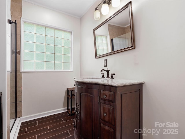 730 Cove Rd, Gastonia, NC 28052 - bathroom with vanity, wood finish floors, crown molding, baseboards, and a shower