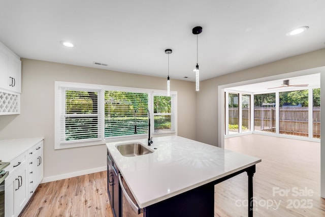 2000 Tyvola Rd, Charlotte, NC 28210 - kitchen featuring light wood-style flooring, light countertops, dishwashing machine, white cabinets, and decorative light fixtures