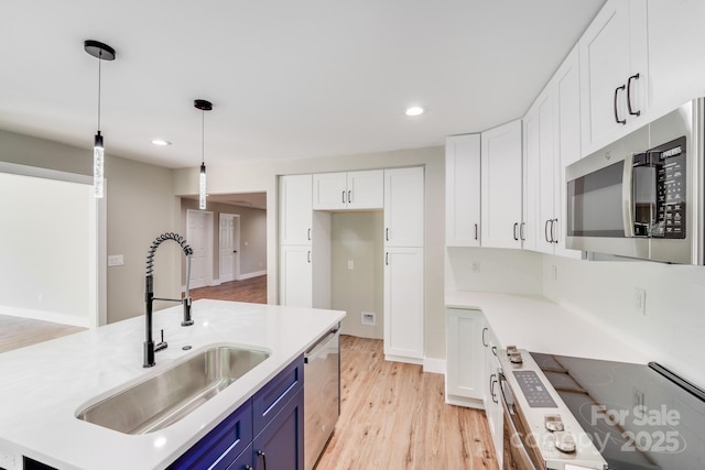 2000 Tyvola Rd, Charlotte, NC 28210 - kitchen with blue cabinetry, stainless steel appliances, white cabinets, light wood finished floors, and light countertops