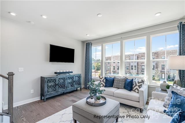 living area with wood finished floors, baseboards, and recessed lighting