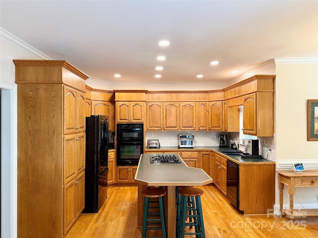 10317 Clubhouse View Ln, Mint Hill, NC 28227 - kitchen featuring black appliances, a kitchen bar, light wood-style flooring, backsplash, and crown molding