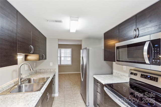 9464 Lexington Cir Unit B, Charlotte, NC 28213 - kitchen featuring stainless steel appliances, a sink, light tile patterned flooring, and light countertops