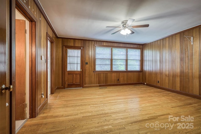 1503 Brentwood Dr, Newton, NC 28658 - empty room featuring light wood-style floors, a ceiling fan, crown molding, baseboards, and wooden walls