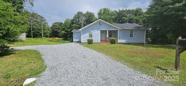 view of front of home featuring gravel driveway, a front yard, and a porch