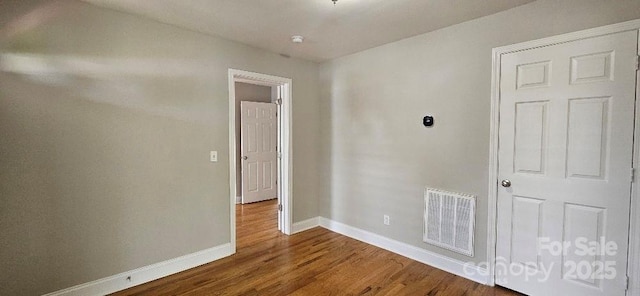 empty room featuring baseboards and wood finished floors