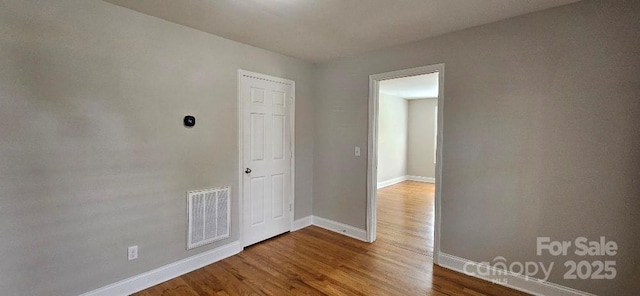 unfurnished room featuring baseboards and wood finished floors