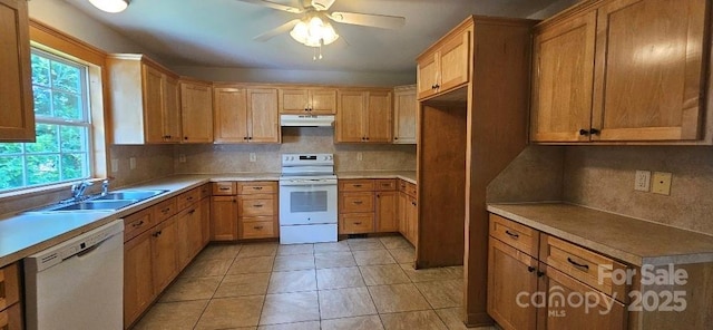 kitchen featuring white appliances, under cabinet range hood, a sink, a ceiling fan, and tasteful backsplash