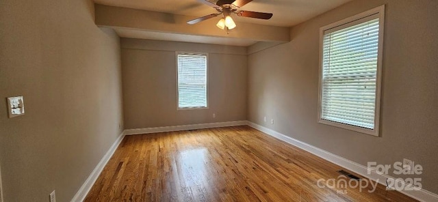 empty room featuring a ceiling fan, wood finished floors, and baseboards