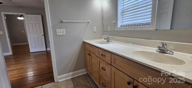 full bathroom featuring double vanity, baseboards, and tile patterned flooring