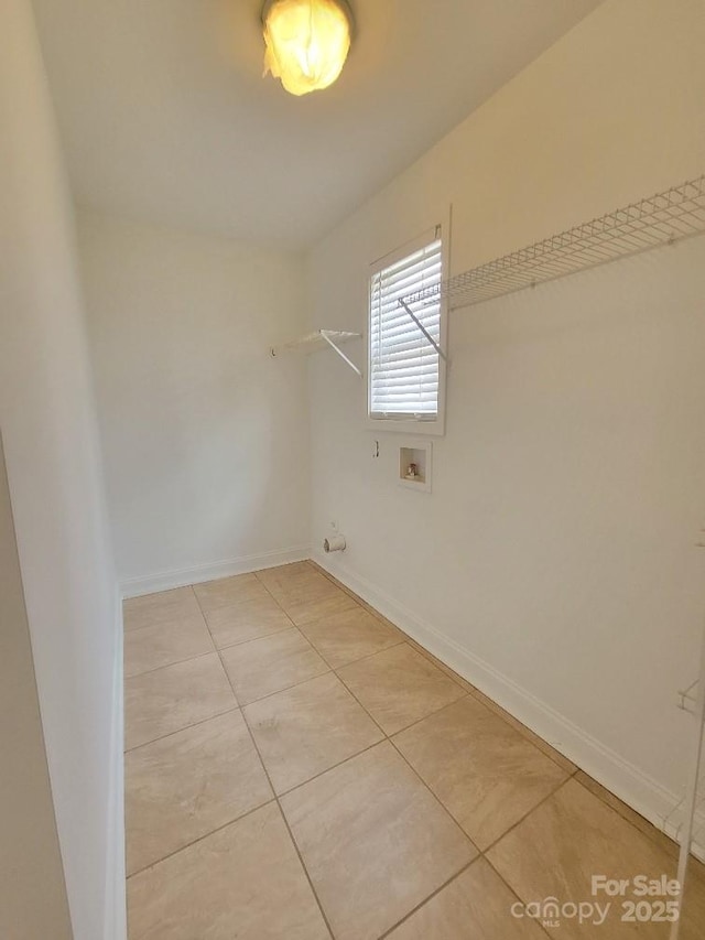 laundry area with hookup for a washing machine, light tile patterned floors, and baseboards