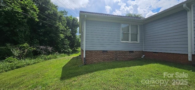 view of side of property featuring crawl space and a lawn