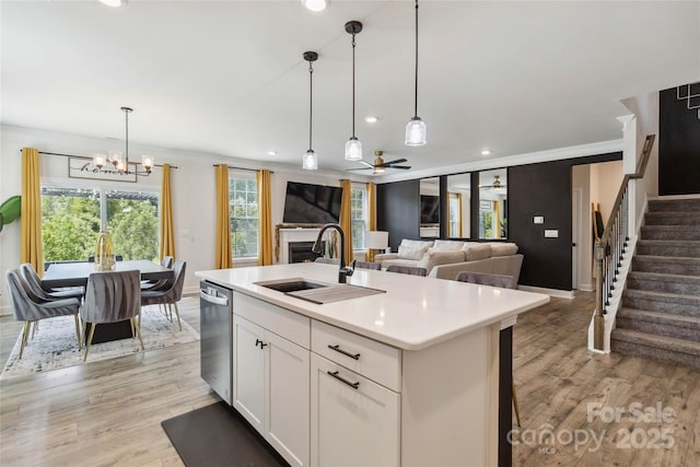 5121 Ennisworth Ln, Charlotte, NC 28214 - kitchen featuring a sink, stainless steel dishwasher, a chandelier, light wood finished floors, and a fireplace