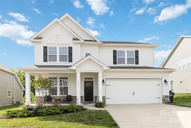 5121 Ennisworth Ln, Charlotte, NC 28214 - craftsman house featuring covered porch, a garage, stone siding, concrete driveway, and central air condition unit