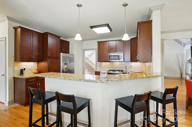 1705 Townsend Ln, Rock Hill, SC 29730 - kitchen with stainless steel appliances, a peninsula, light wood-style floors, decorative backsplash, and ornamental molding