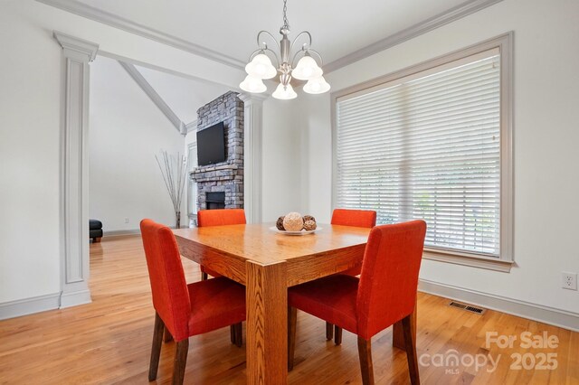 1705 Townsend Ln, Rock Hill, SC 29730 - dining space featuring a fireplace, a chandelier, light wood finished floors, baseboards, and lofted ceiling