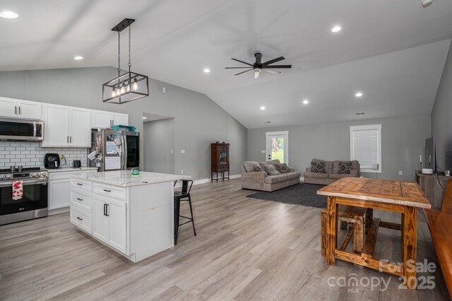 1138 Zeb Haynes Rd, Maiden, NC 28650 - kitchen with stainless steel appliances, open floor plan, lofted ceiling, a kitchen bar, and white cabinetry