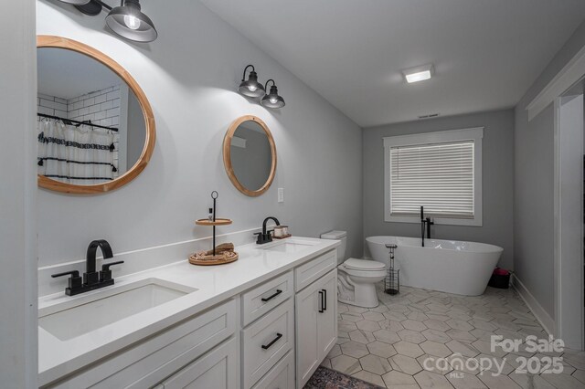1138 Zeb Haynes Rd, Maiden, NC 28650 - bathroom with double vanity, a freestanding bath, tile patterned flooring, toilet, and a shower with shower curtain