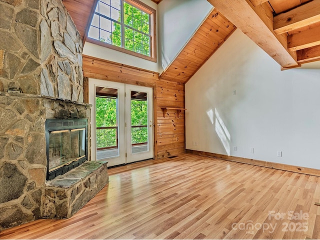 287 Sara Ridge Rd, Waynesville, NC 28786 - unfurnished living room featuring healthy amount of natural light, wood finished floors, high vaulted ceiling, a fireplace, and baseboards
