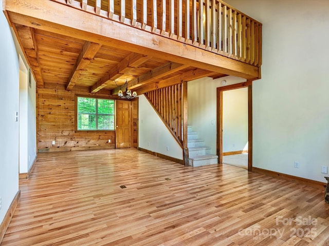 287 Sara Ridge Rd, Waynesville, NC 28786 - unfurnished living room with wooden ceiling with exposed beams, a chandelier, wood finished floors, stairs, and baseboards
